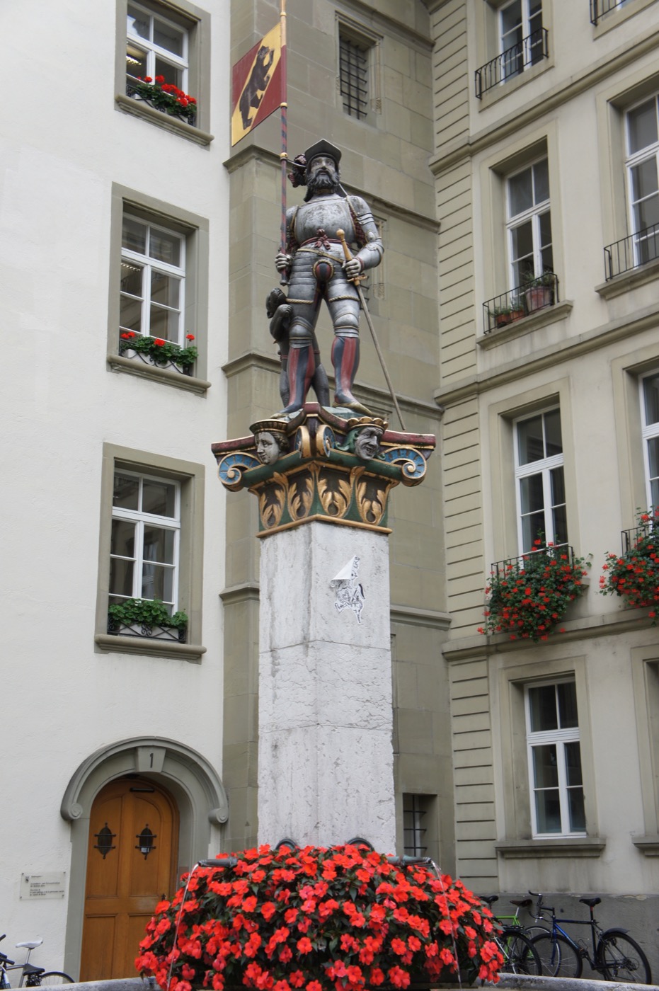 州庁舎の前に立つ「旗手の泉（Vennerbrunnen）」。銀色に輝く甲冑を身にまとい、片手に旗ざお、片手に剣を持った騎士の像だ。足もとには