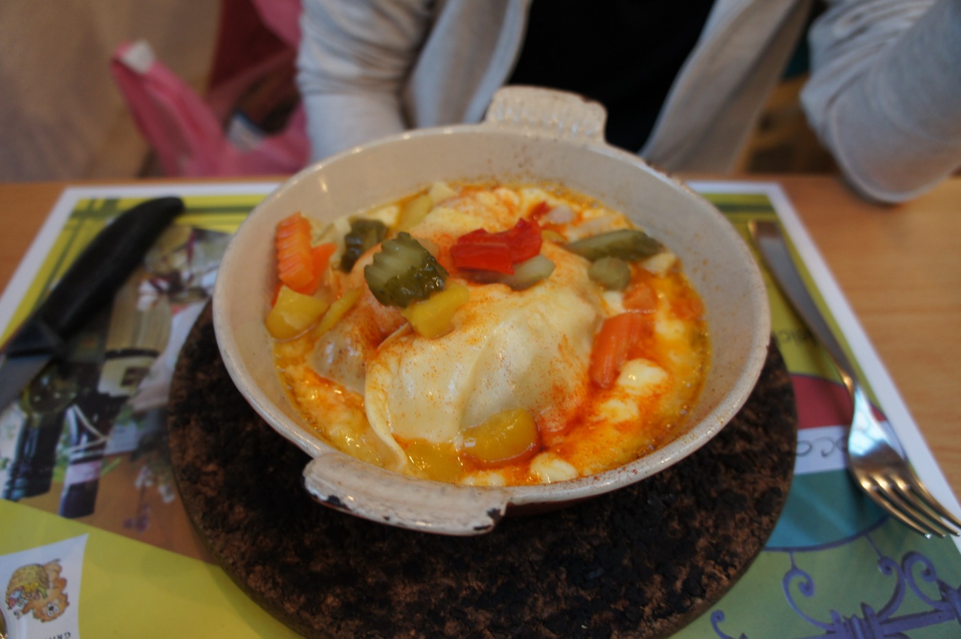 そしてもう一品、熱々の石のプレートにのった、チーズをたっぷりからめた煮込み料理。ピクルスや彩り野菜が添えられている。山のごちそうは、とにかく