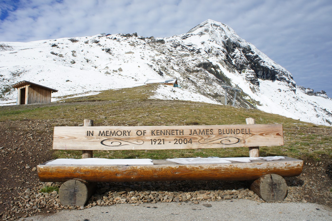道ばたのベンチには「IN MEMORY OF KENNETH JAMES BLUNDELL 1921–2004」の銘板。この絶景を愛した人の