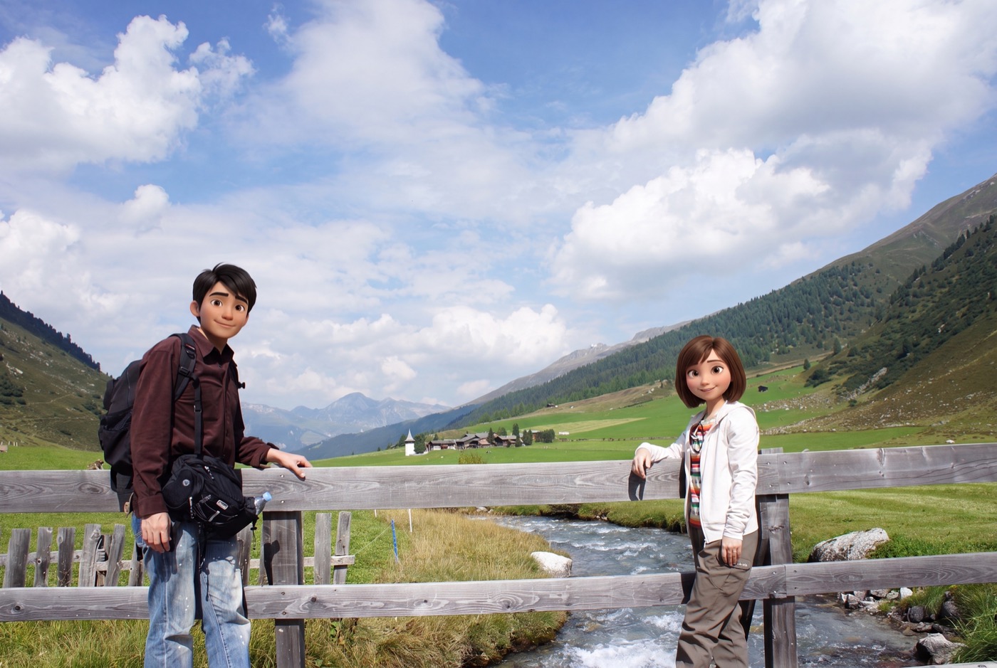 谷の真ん中を、雪解け水の小川がさらさらと流れている。木の柵にもたれて、二人で記念に一枚。振り返ると、緑の谷の奥に小さな教会の尖塔と集落、そし